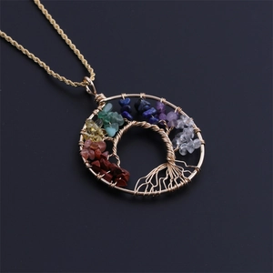 Macro view of gold wire-wrapped Tree of Life pendant with colorful seven chakra stones