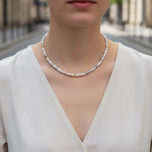 Detailed view of beaded malachite necklace with white marble beads and gold accents