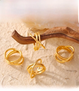 Detail of multi-layered intertwined gold rings with PVD plating on a natural wood branch