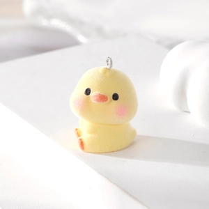 Macro shot of a yellow flocked chick pendant with metal loop for DIY jewelry design