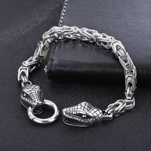 Gros plan du bracelet punk argenté avec têtes de serpent sur cuir noir