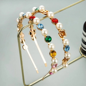 Détail d'un serre-tête baroque avec cristaux colorés, perles blanches et roses dorées
