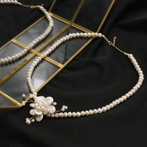 Baroque petal freshwater pearl necklace with flower pendant on black silk background