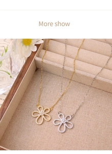 Macro detail of silver and gold flower pendants with zircon pavé on link chain necklaces
