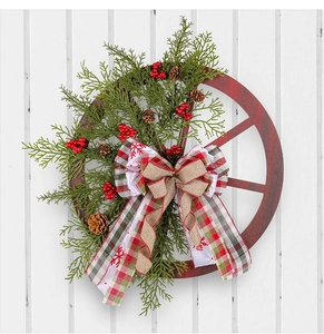 Close-up of a Christmas wreath with a red wooden wheel, pine cones, and a burlap bow
