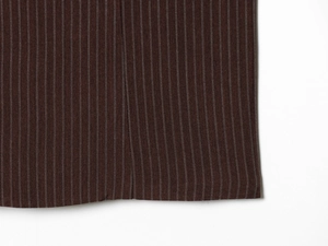 Gros plan d'un tissu marron à fines rayures montrant le tissage et les coutures
