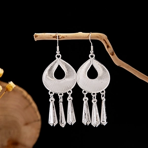 Detailed view of silver ethnic hollow teardrop earrings with cone tassel pendants