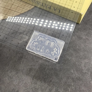 Macro detail of clear silicone nail mold featuring stars, wings, and unicorn patterns