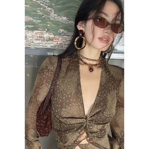 Detail of vintage coffee-colored floral long-sleeved top with deep V-neck and buttons