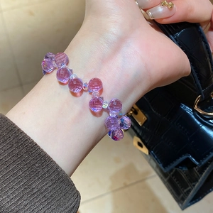 Detail of irregular purple crystal beaded bracelet on wrist with elegant faceted gems