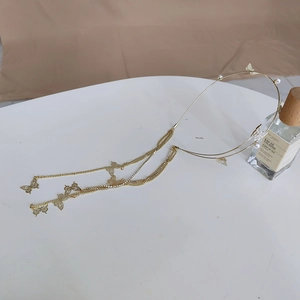Close-up of golden headband with elegant butterfly pendants and long tassel chains