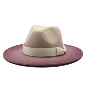 Detail of wool fedora hat showing beige crown with purple wide brim and ribbon bow
