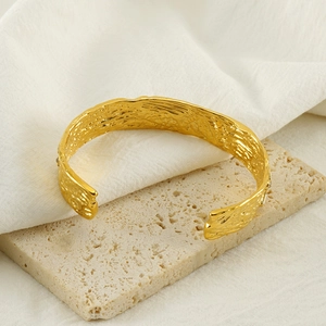 Vintage gold-plated titanium steel open bangle featuring a unique textured lava surface