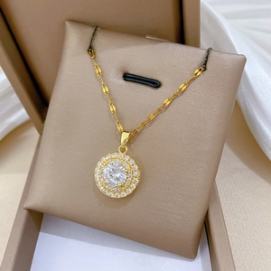 Luxurious gold titanium necklace with a large crystal round pendant in a beige jewelry box