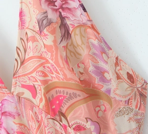 Detail shot of pink paisley printed maxi dress with silky v-neck and vibrant floral patterns