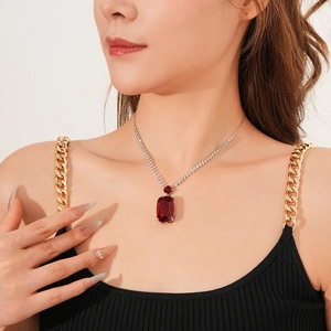 Close-up of a silver chain necklace with a large wine red rectangular zircon pendant