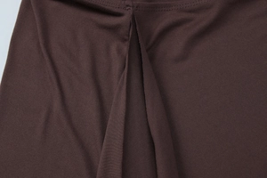 Macro shot of dark brown knit fabric texture showing seamless stitching and soft drape