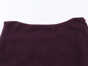 Gros plan sur la maille épaisse violet foncé montrant la découpe d'épaule et la texture