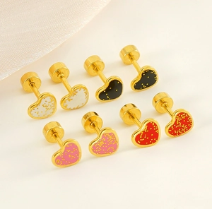 Gros plan de quatre paires de boucles d'oreilles cœur pailletées dorées et émail