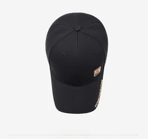 Top view of black baseball cap featuring gold embroidered lettering and metal NY plaque