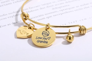 Detail of adjustable gold bracelet with Grandma heart charm and round engraved pendant