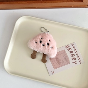 Detail of pink plush cloud charm with embroidery and silver bead chain on a tray