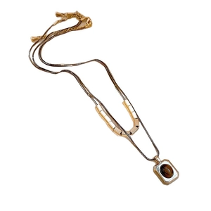 Double-layered 18k gold plated necklace with oval tiger eye stone pendant on white background