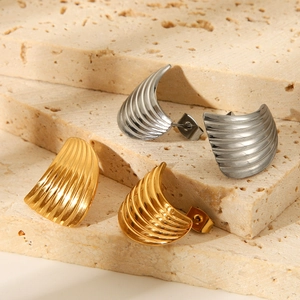 Striped fan-shaped titanium steel earrings in gold and silver on stone display