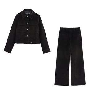 Détail de la texture en velours côtelé noir sur l'ensemble veste courte et pantalon