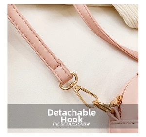Detail of the pink leather bag showing the detachable golden metal hook and fine stitching