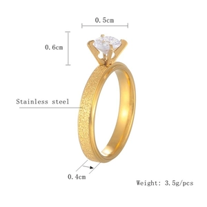 Detailed macro view of gold stainless steel ring with zircon stone and size info