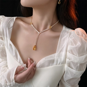 Close-up of model wearing yellow pear-cut zircon necklace and matching earrings set