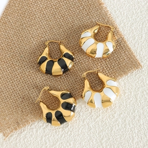 Orecchini a cerchio geometrici con smalto bianco e nero e finitura dorata di tendenza