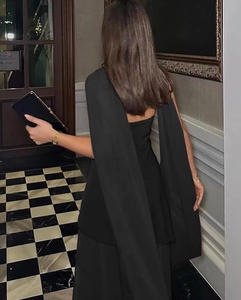 Rear view of an elegant backless black gown with shawl sleeves in a luxury interior