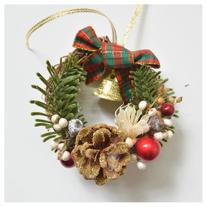 Detail of Christmas wreath with pine cones, metal bells and red plaid ribbon bow