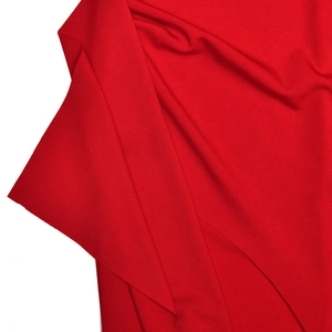 Detail view of red knitted fabric texture with soft drape and fine pleats