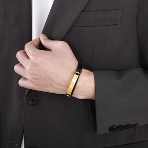 Detail eines Herren-Lederarmbands mit goldener Metallplatte am Handgelenk getragen