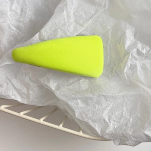 Detail of neon green fabric sponge hair clip in a modern triangular shape