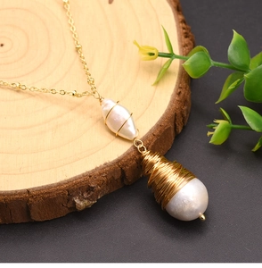 Macro detail of baroque pearls with golden wire wrapping on a wooden texture background