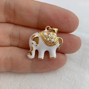 Detailed close-up of a white enamel elephant pendant with gold plating and rhinestones