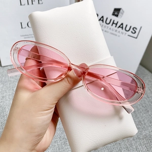 Close-up of pink oval cat-eye sunglasses with jelly frame and soft faux leather pouch