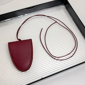 Détail d'un porte-lunettes en cuir bordeaux avec surpiqûres et cordon de cou réglable