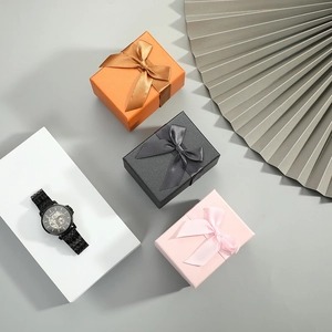 Square gift boxes in orange black and pink with ribbons for premium watch packaging