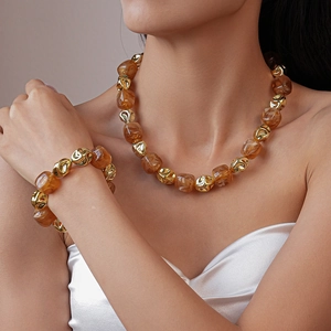 Detail of amber acrylic and gold geometric beads on necklace and bracelet set