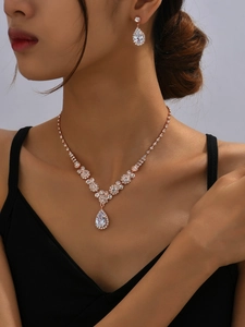 Close-up of rose gold bridal jewelry set with sparkling rhinestones on an elegant model