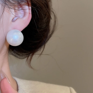 Close-up of 12-14mm elegant white pearl stud earring worn on model for a luxury look