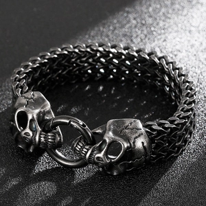 Detailed view of punk style double skull metal bracelet with gothic braided chain link