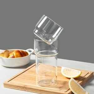 Stackable high borosilicate glass coffee cups set on a wooden board with lemon slices