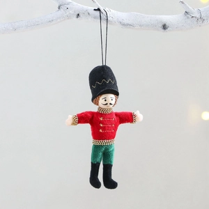 Nutcracker plush ornaments in multi-color hanging on white branches for Christmas decor