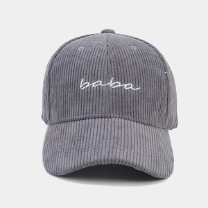 Close-up of grey corduroy baseball cap with white baba embroidery and six-panel structure